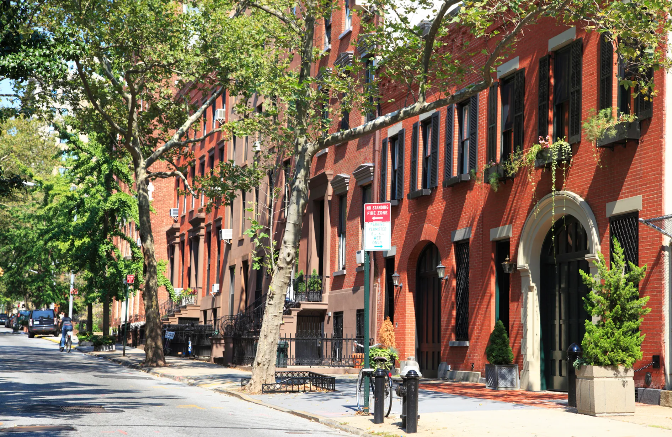 Tree-lined street with historic red brick townhomes in Brooklyn Heights, NYC